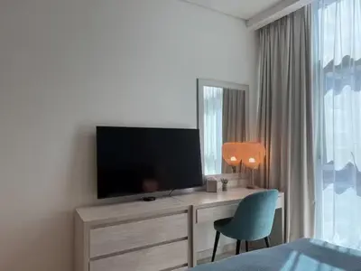 a bedroom with a desk with a television and a chair at Studio in Seven Palm in Dubai