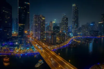 a city skyline at night with a river and buildings at Luxury Marina View 2BR Apartment for 6 in Dubai