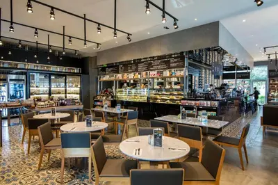 a restaurant with tables and chairs and a bakery at Luxury Marina View 2BR Apartment for 6 in Dubai
