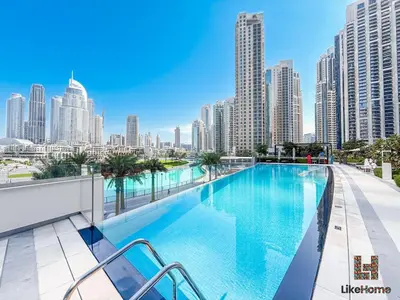 a swimming pool with a city skyline in the background at Wake up To Burj Khalifa Views Luxury 2 BR LikeHome in Dubai