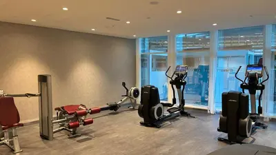 a gym with several treadmills and cardio machines at Damac Maison The Distinction 1 BHK Burj Khalifa in Dubai