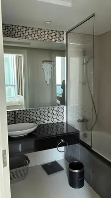 a bathroom with a sink and a tub and a mirror at Damac Maison The Distinction 1 BHK Burj Khalifa in Dubai