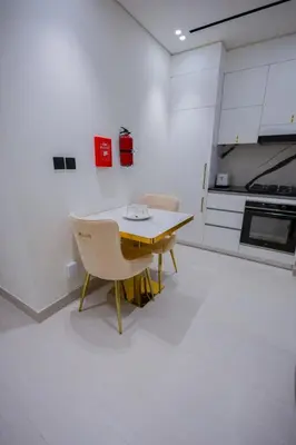 a kitchen with a table and chairs in a room at Luxury Studio with Private Jacuzzi at Trillionaire, Business Bay in Dubai
