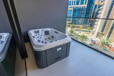 a bath tub in a bathroom with a view of a city at Luxury Studio with Private Jacuzzi at Trillionaire, Business Bay in Dubai