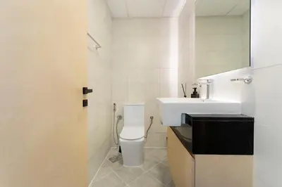a white bathroom with a toilet and a sink at Modern 1BR with Pool & Gym, Burj Khalifa View, Al Jaddaf in Dubai