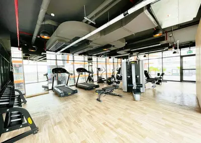 a gym with several treadmills and elliptical machines at Modern 1BR with Pool & Gym, Burj Khalifa View, Al Jaddaf in Dubai