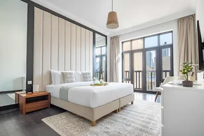 a bedroom with a large bed and large windows at Frank Porter - Al Tajer Residences in Dubai