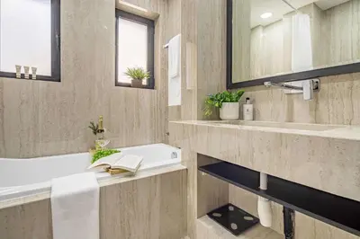a bathroom with a tub and a sink and a mirror at Frank Porter - Al Tajer Residences in Dubai