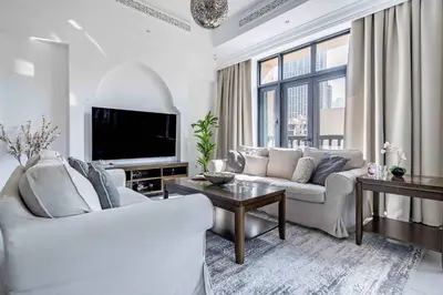 a living room with white furniture and a flat screen tv at Frank Porter - Al Tajer Residences in Dubai