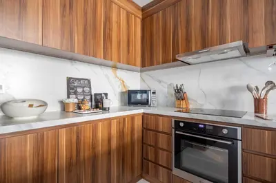 a kitchen with wooden cabinets and a black oven at Frank Porter - Blvd Central in Dubai