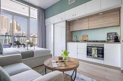 a living room with a couch and a bed and a table at Frank Porter - Studio One Tower in Dubai