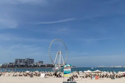 a ferris wheel on a beach near the ocean at Frank Porter - Studio One Tower in Dubai