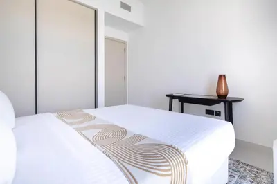 a bedroom with a white bed and a table at Frank Porter - Marina Vista Tower 2 in Dubai