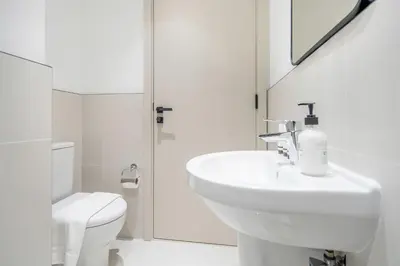 a white bathroom with a sink and a toilet at Frank Porter - Marina Vista Tower 2 in Dubai