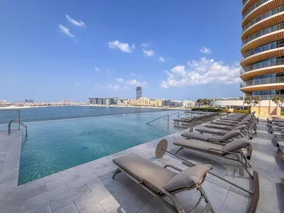 a swimming pool with lounge chairs on the roof of a building at Frank Porter - Marina Vista Tower 2 in Dubai