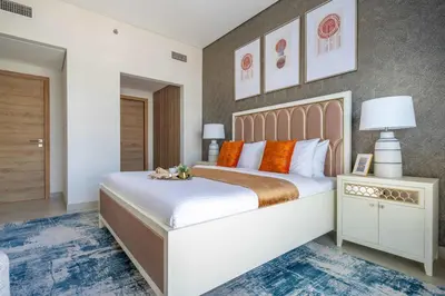 a bedroom with a large white bed with orange pillows at Frank Porter - Eleganz 2 by Danube in Dubai