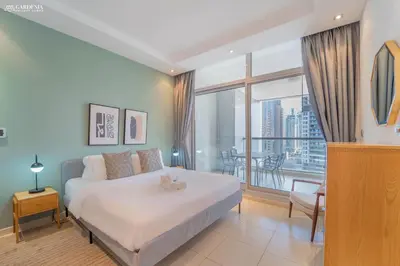 a bedroom with a bed and a large window at SkyView Tower - Dubai Marina View - Lit Apartment in Dubai