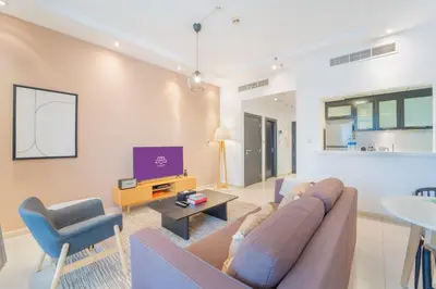 a living room with a couch and a tv at SkyView Tower - Dubai Marina View - Lit Apartment in Dubai