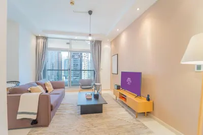 a living room with a couch and a table at SkyView Tower - Dubai Marina View - Lit Apartment in Dubai