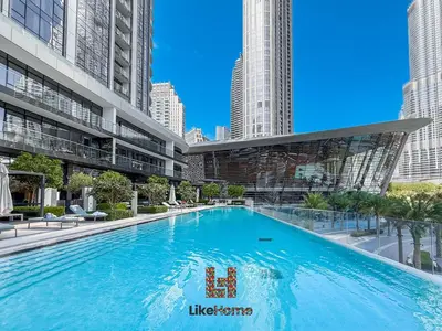 a large swimming pool in a building with tall buildings at Wake Up to Burj Khalifa Views Next to Dubai Mall Luxury 2BR Downtown Like Home in Dubai