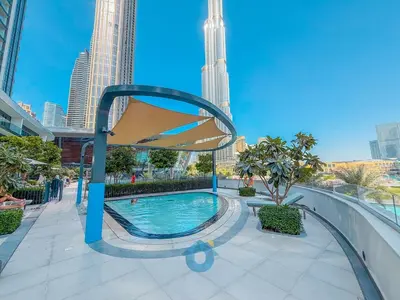 a swimming pool in a city with tall buildings at Enjoy Best Burj Khalifa View from Balcony Next to Dubai Mall Luxury 2BR Like Home in Dubai