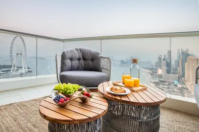 a living room with a table and a chair with food on it at Lux 2BR Beachfront ap with icon Palm view in Dubai