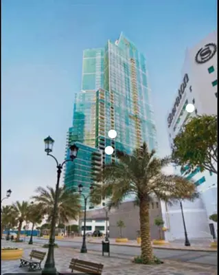 a tall building with palm trees and street lights at Lux 2BR Beachfront ap with icon Palm view in Dubai