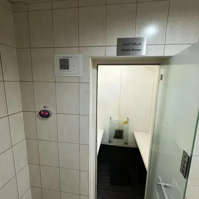 a bathroom with a door leading to a small room at Stylish Studio Apartment in JVC in Dubai