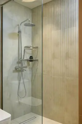 a shower with a glass door in a bathroom at Stylish Studio Apartment in JVC in Dubai