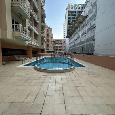 a swimming pool in the middle of a building at Stylish Studio Apartment in JVC in Dubai