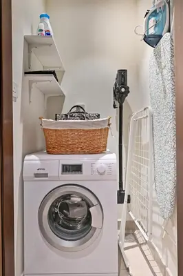 a washing machine with a basket on top in a laundry room at Stunning 1BR Luxury Downtown Burj View Balcony in Dubai