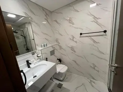 a white bathroom with a sink and a toilet at Captivating Studio in Jvc Elysee in Dubai