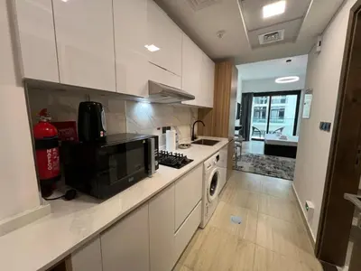 a kitchen with a stove and a microwave at Captivating Studio in Jvc Elysee in Dubai