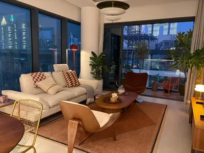 a living room with a couch and tables and windows at Stylish 1BR in CityWalk, Stunning Burj Khalifa view in Dubai