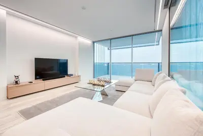 a living room with a white couch and a television at Luxury Apartment at Muraba Residence in Dubai