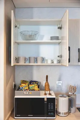 a kitchen with a microwave and some food on a counter at Bay Central Marina Suite with Exceptional Views in Dubai