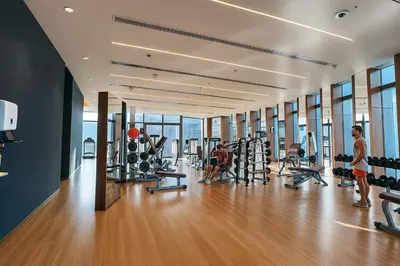 a gym with tread machines and people in it at Luxury 2BR with Full Burj Khalifa View in Dubai