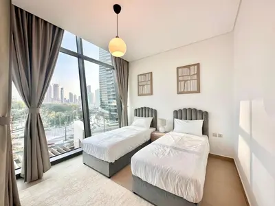 two beds in a room with a large window at Luxury 2BR with Full Burj Khalifa View in Dubai