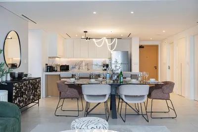a kitchen and dining room with a table and chairs at Luxurious 4BR La Vie JBR Private Beach Pool Panoramic Sea and Dubai Eye Views Drone Show Perfect for Family and Friends in Dubai