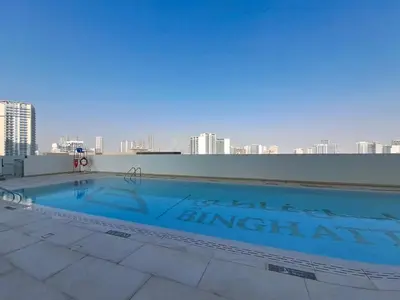 a large swimming pool on the roof of a building at Vacationer l Contemporary 1 Bed l City Views l near Circle Mall in Dubai