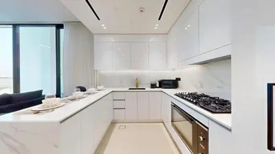 a kitchen with white cabinets and a stove top oven at Vacationer l Classy 2 Bedroom l Private Jacuzzi l near Circle Mall in Dubai