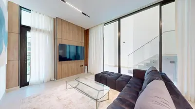 a living room with a large couch and a tv at Vacationer l Classy 2 Bedroom l Private Jacuzzi l near Circle Mall in Dubai