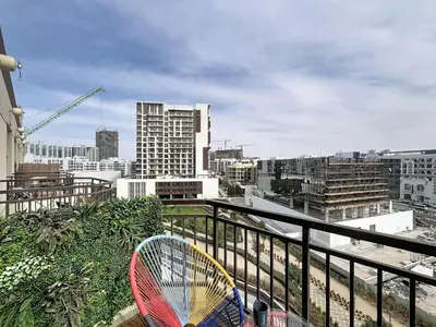 a tennis racket sitting on a balcony with a city at Vacationer I Modern Studio I Pool & Gym Access I 5-min Drive to Miracle Garden I Arjan in Dubai