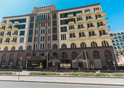 a building on the corner of a street at Vacationer I Modern Studio I Pool & Gym Access I 5-min Drive to Miracle Garden I Arjan in Dubai