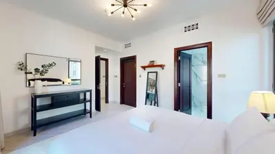 a white bedroom with a white bed and a mirror at Vacationer l Upgraded Modern 2 Bed l Downtown l Near Dubai Mall in Dubai