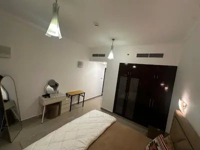 a bedroom with a bed and a table and lights at Spacious 1 Bedroom Apartment-Opal Tower Dubai Marina in Dubai