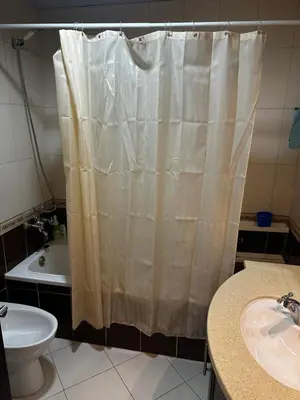 a bathroom with a shower curtain and a sink at Spacious 1 Bedroom Apartment-Opal Tower Dubai Marina in Dubai