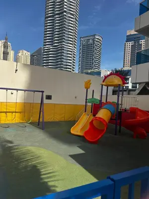 a playground with a slide and a swing set at Spacious 1 Bedroom Apartment-Opal Tower Dubai Marina in Dubai