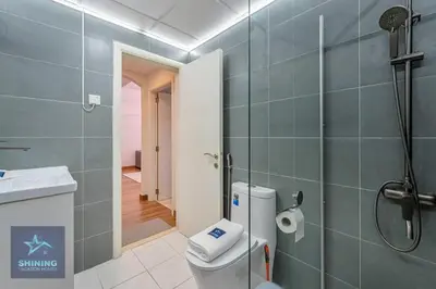 a bathroom with a shower and a toilet and a sink at Modern 1BR Apartment in JVC Pool Gym Near Circle Mall in Dubai