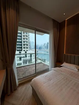 a bedroom with a large window with a view at Burj Khalifa & Canal View Apartment in Dubai